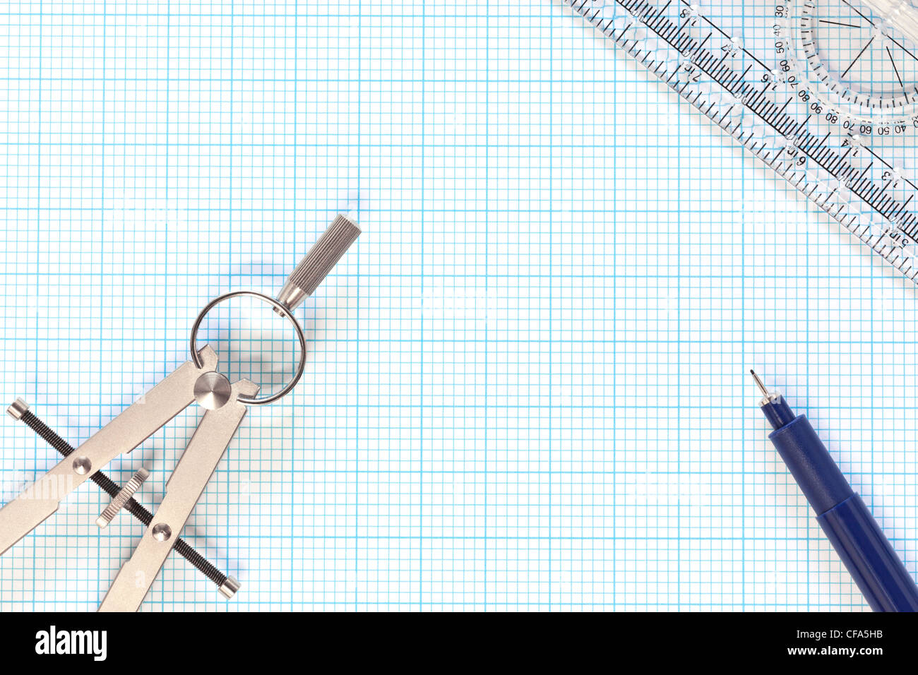 Still life photo of engineering graph paper with a fine 0.1mm pen, compass and protractor ruler Stock Photo