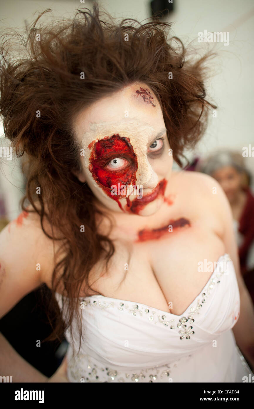 a young woman wearing full prosthetic makeup  taking part in a Zombie bride 'trash the wedding dress' event Stock Photo