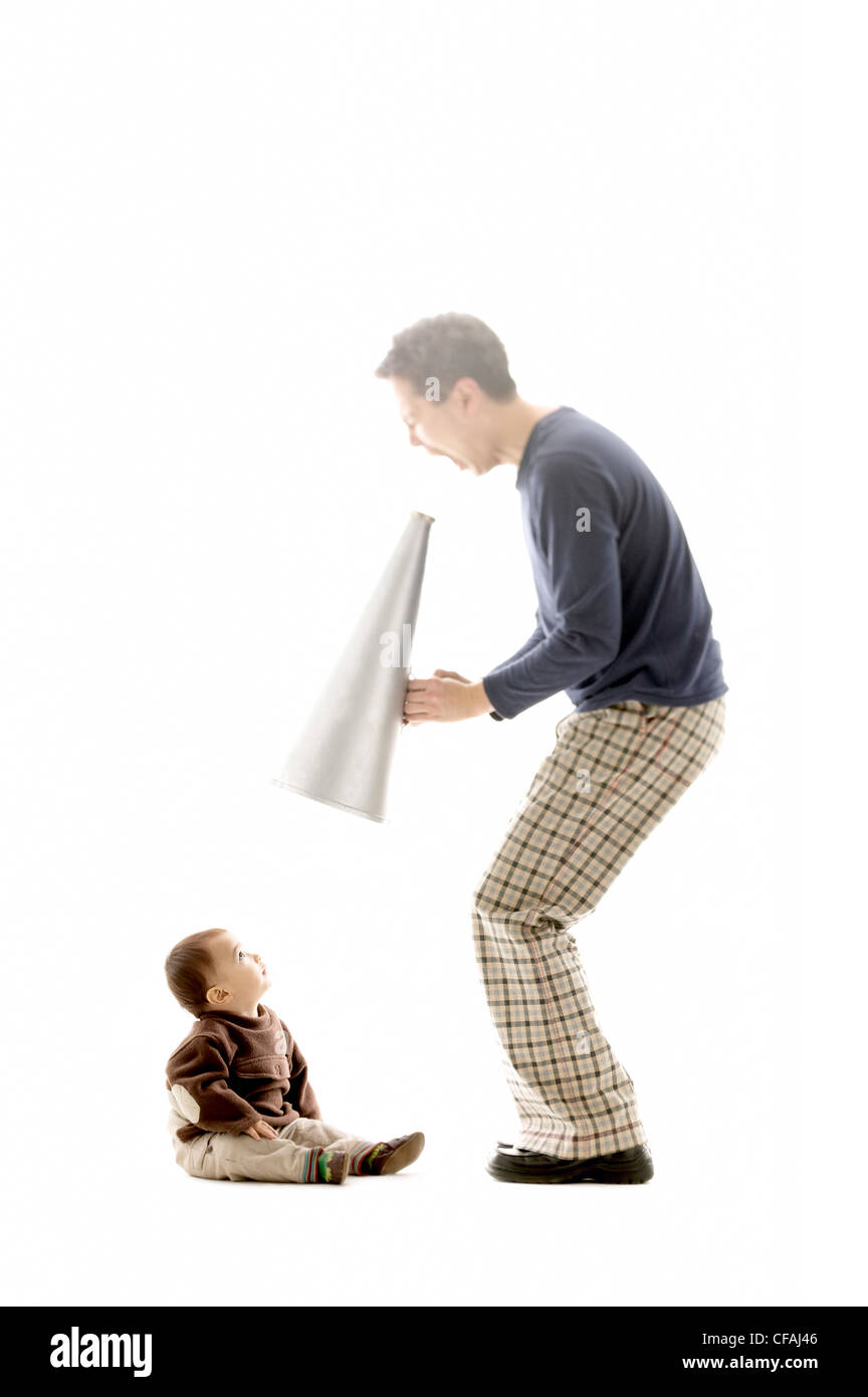 43 year old asian man shouting through a megaphone at a 10 months old Eurasian baby boy, Montreal, Quebec, Canada. Stock Photo