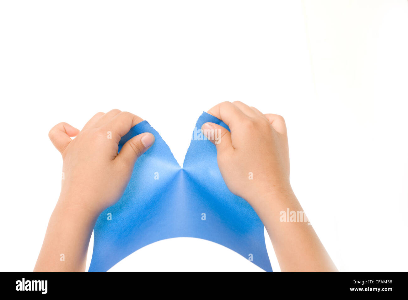 Hands tearing a precut sheet of blue paper isolated on white Stock Photo