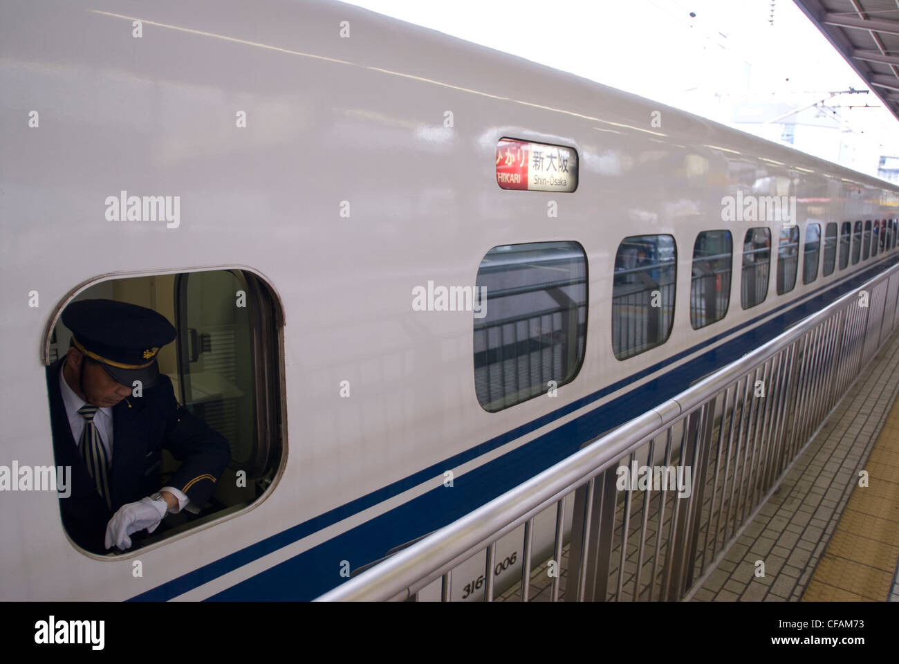 Conductor checks his watch as his Shinkansen is about to depart for Shin-Osaka, Japan. Stock Photo