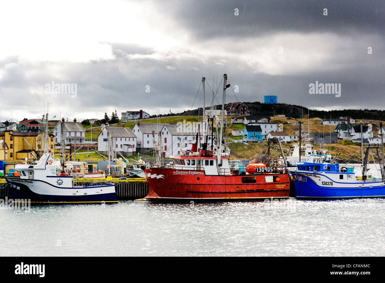 Fishing boats tied up to wharf in the rain, Bonavista, Newfoundland and Labrador, Canada. Stock Photo
