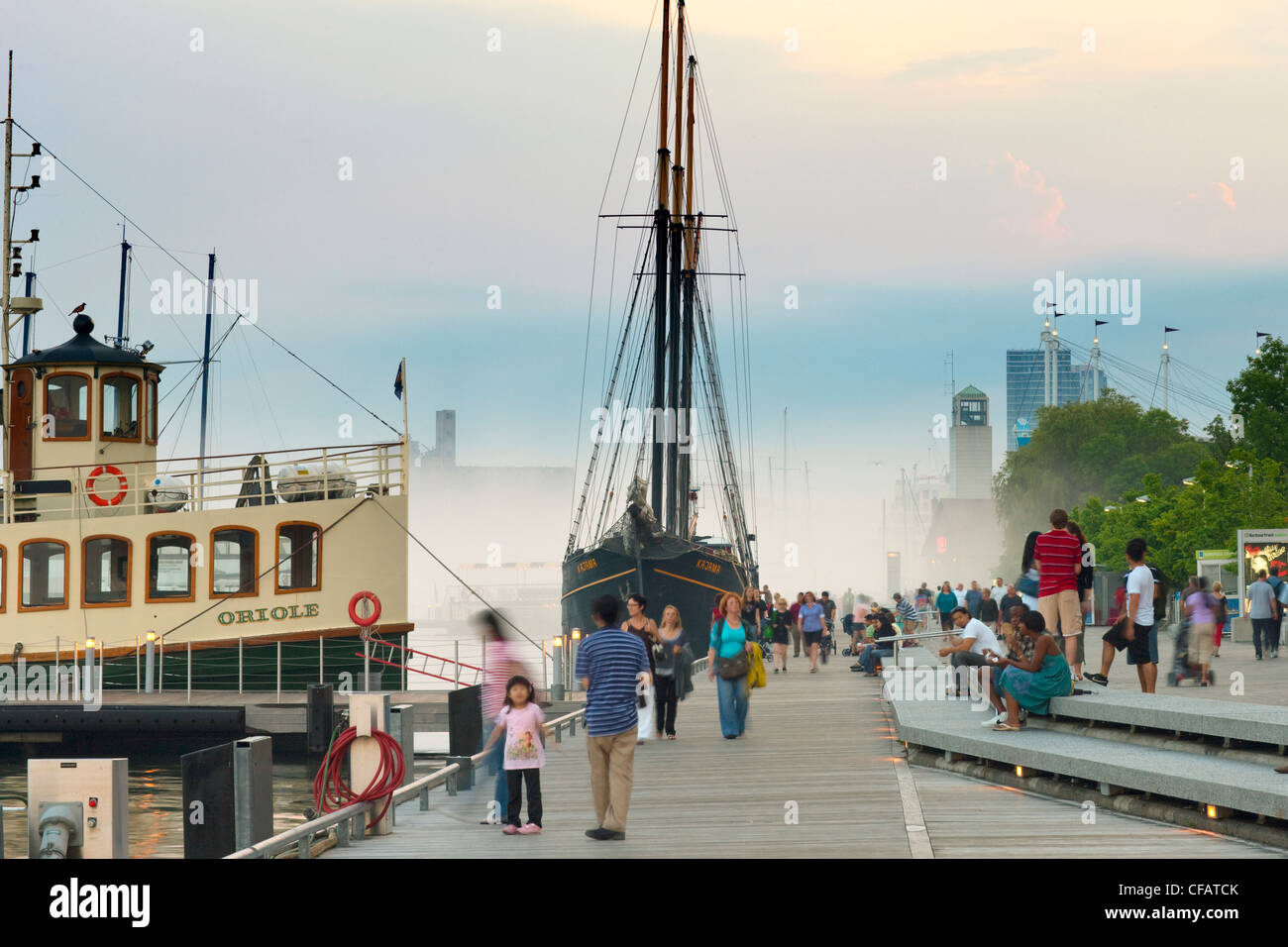 Sailing ship and tour boat docked at Toronto waterfront at dusk, Ontario, Canada. Stock Photo