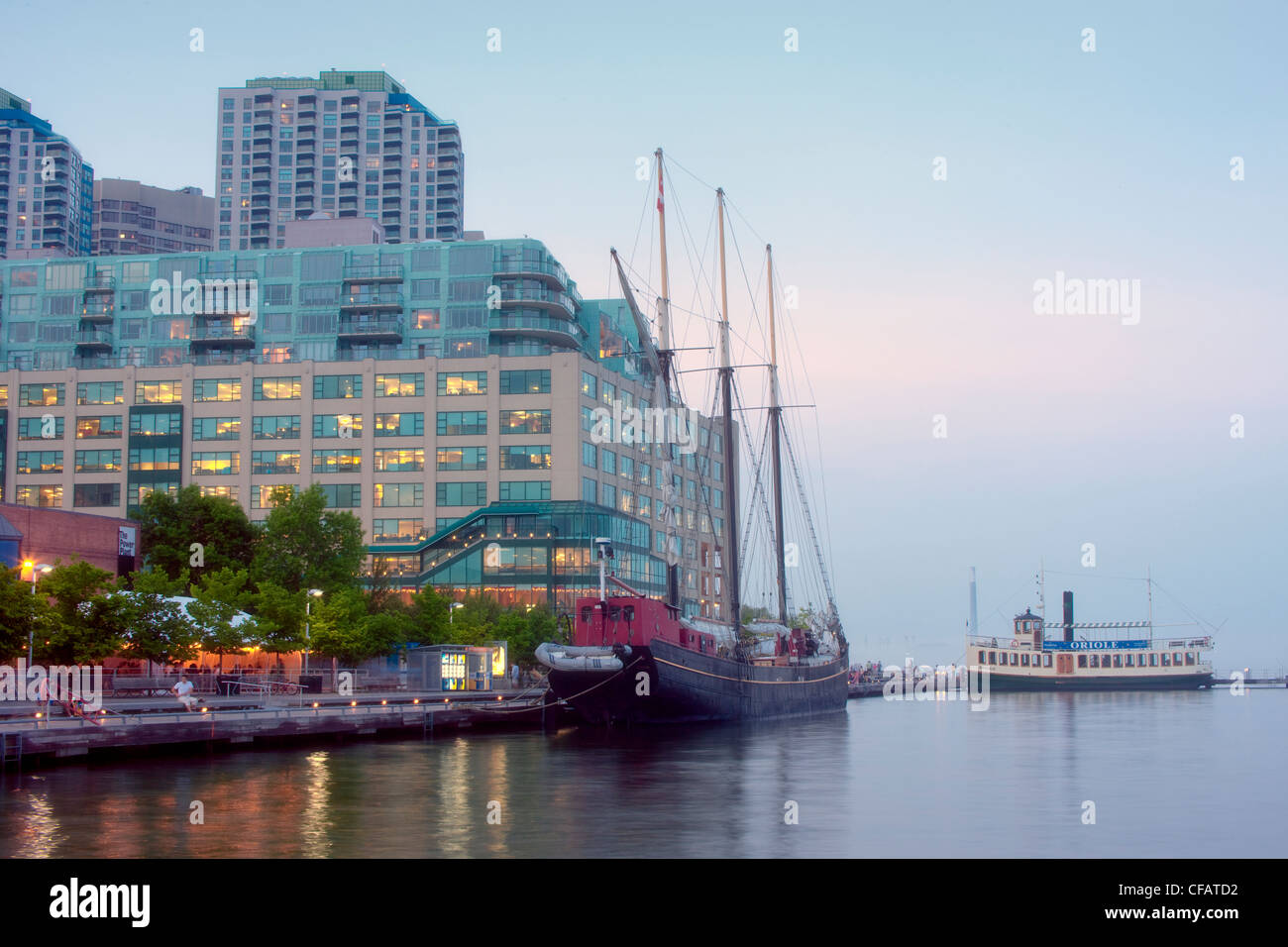 Sailing ship and tour boat docked at Toronto waterfront at dusk, Ontario, Canada. Stock Photo