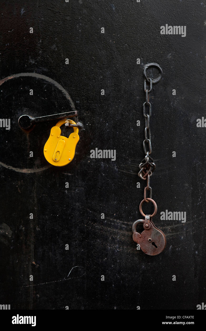 2 locks on door, one yellow, one rusty, Whitechapel, London Stock Photo