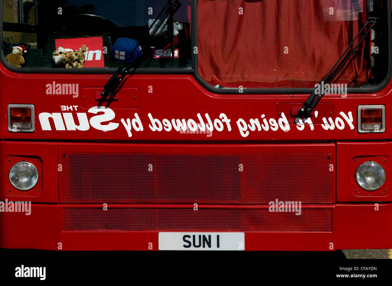 Red London Bus with the Sun newspaper advertised on the front. Stock Photo