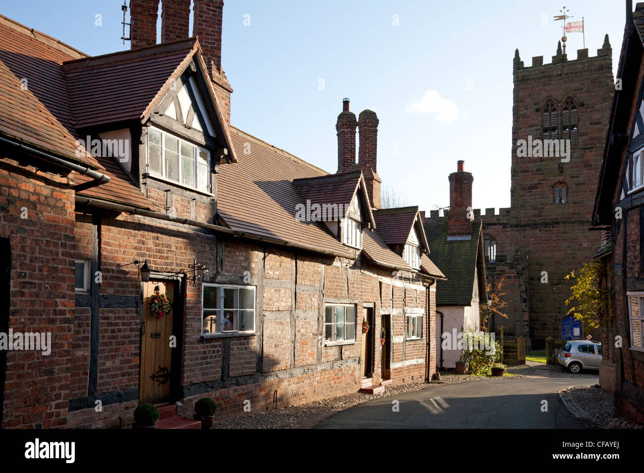 Cottages in Church Street, with St Mary & All Saints' Church in the background, Great Budworth, Cheshire Stock Photo