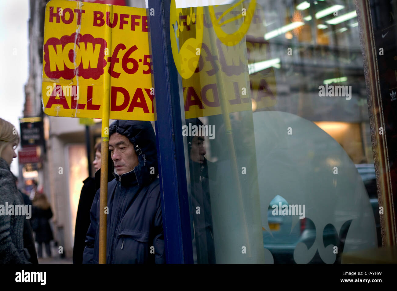 Man with resturant sign in rain, Chinatown, London. Stock Photo