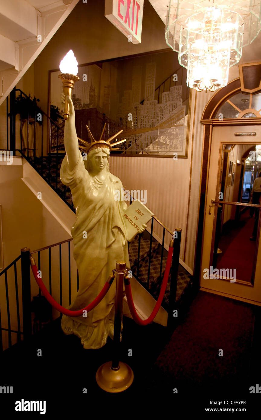 A marble miniature replica of the Statue of Liberty beside a staircase in a hotel lobby Stock Photo