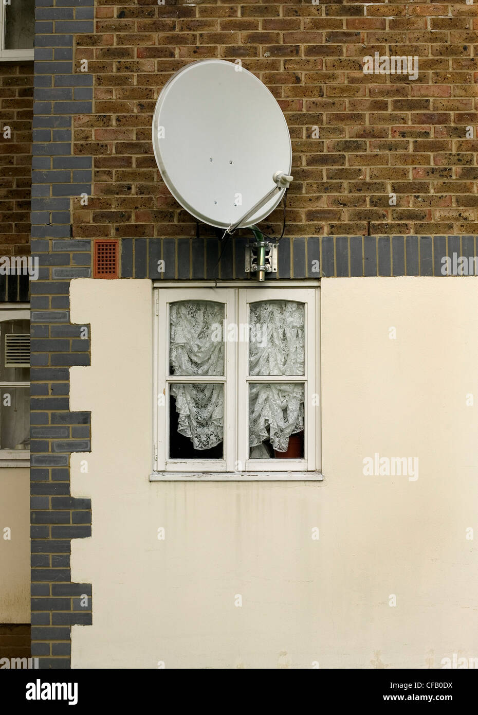 satellite dish on the wall of a council house Stock Photo