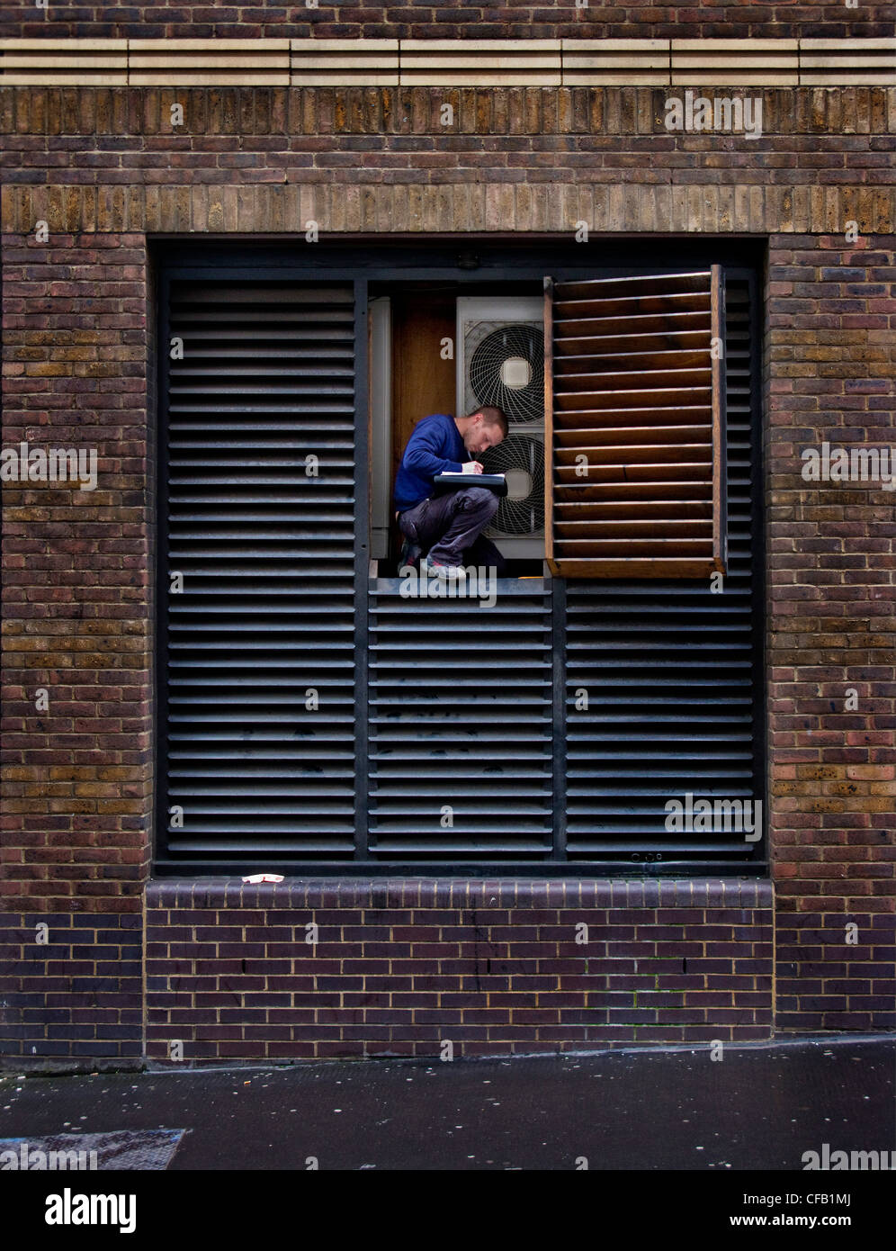Man repairing air conditioning, London Stock Photo