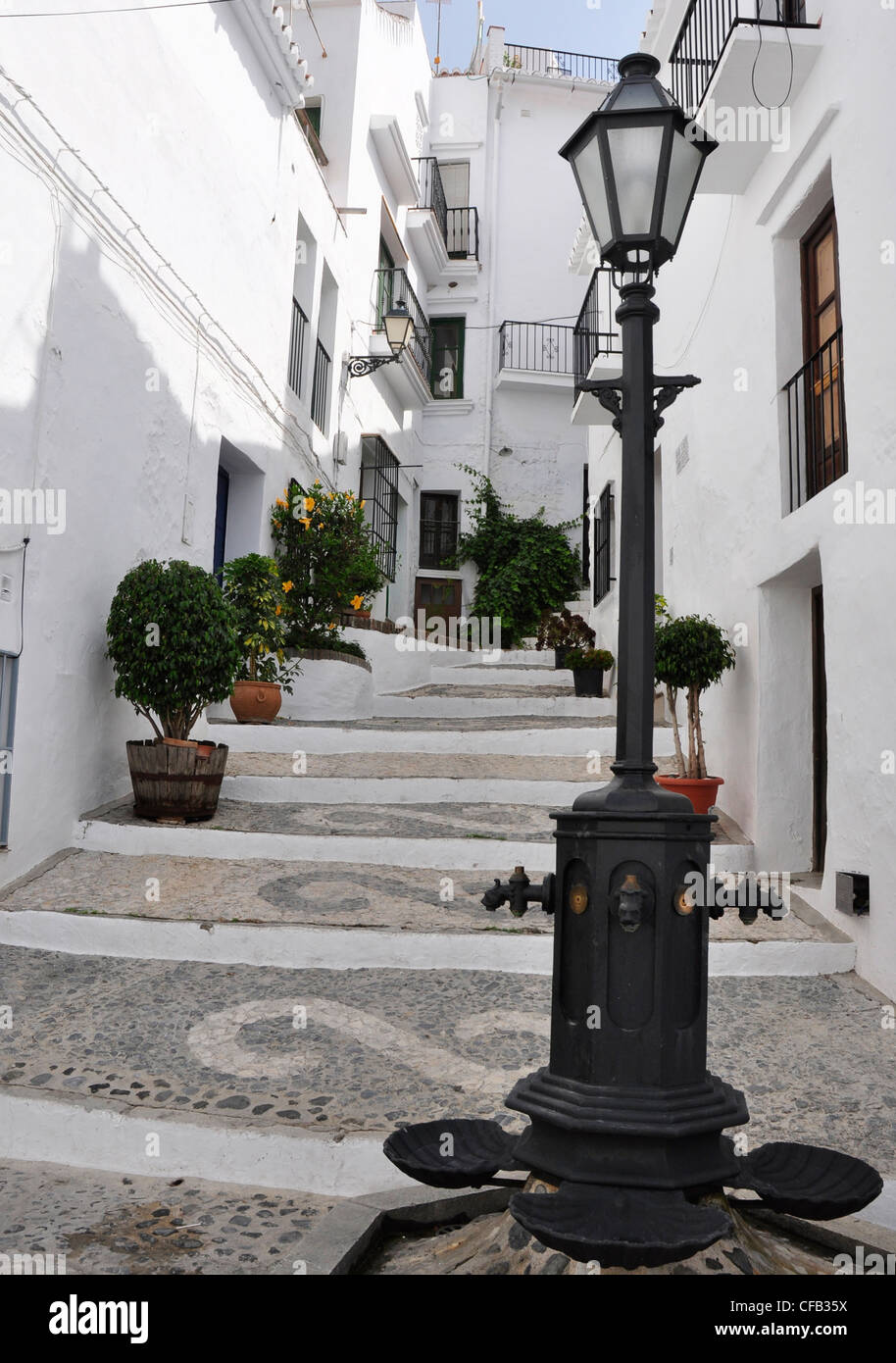 Spain - Andalucia - Frigiliana - cobbled lane with mosaic decorations - ironwork lamp standard - white washed houses. Stock Photo