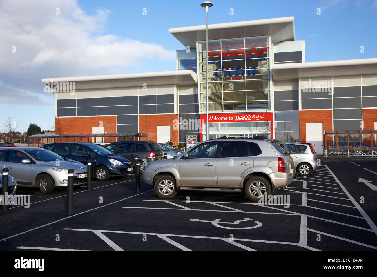 disabled car parking spaces outside tesco extra supermarket outside Belfast Northern Ireland UK Stock Photo