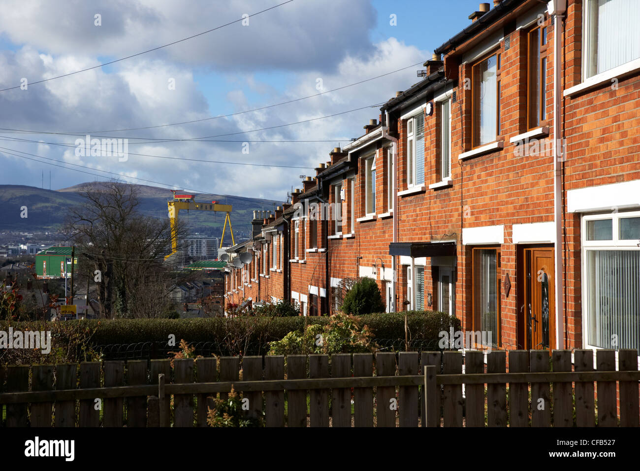 row of terraced houses family homes leading downhill towards the shipyard east Belfast Northern Ireland UK Stock Photo