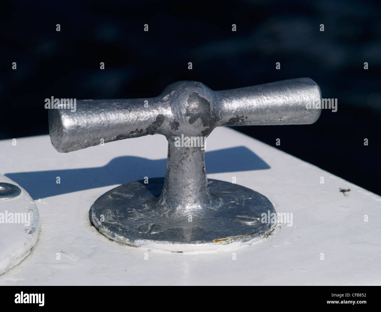 A nautical cleat on the deck of a small motor boat used for mooring the