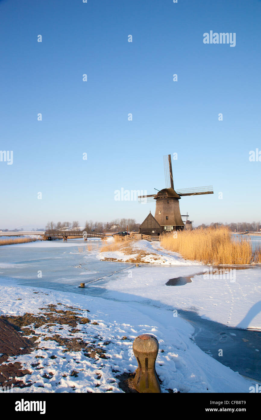 Windmill in winter time with snow and blue sky Stock Photo