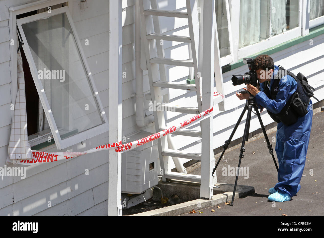 A police photographer at the scene of an assault on a male resident, Eden Park Lodge, Dominion Road, Auckland, New Zealand Stock Photo