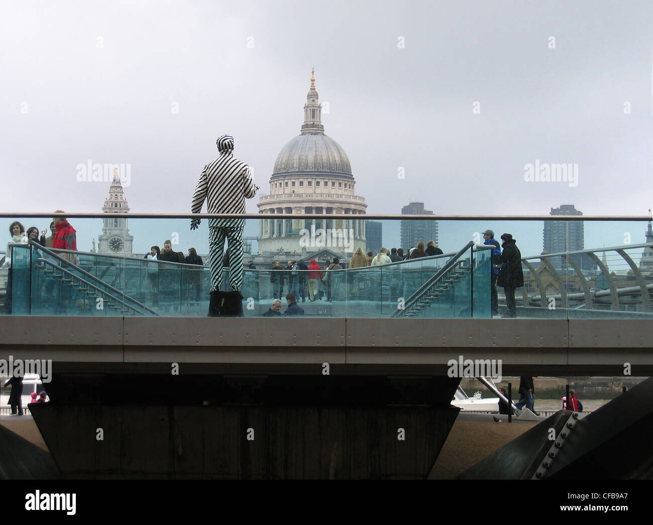 Millennium footbridge bridge facing St Pauls cathedral with human statue in the foreground Stock Photo