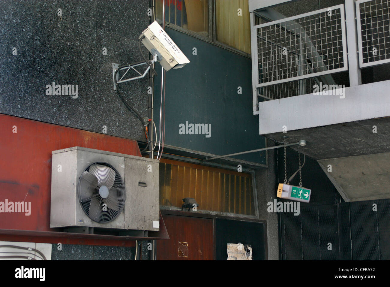 Closed Circuit television camera alongside an air-conditioning vent at the back of a building Stock Photo