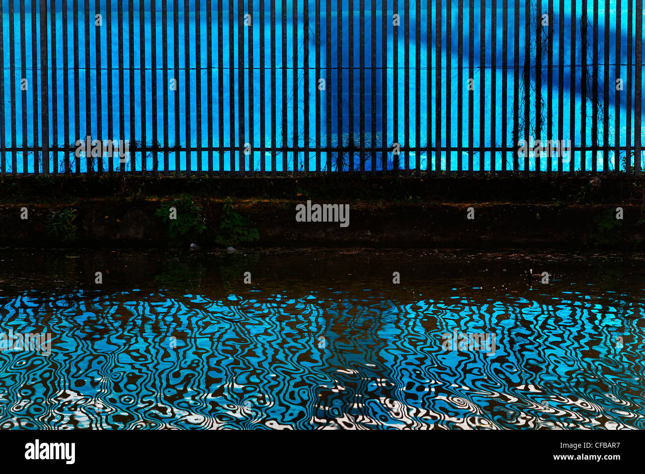 Reflections of fence in canal, London, UK. Stock Photo