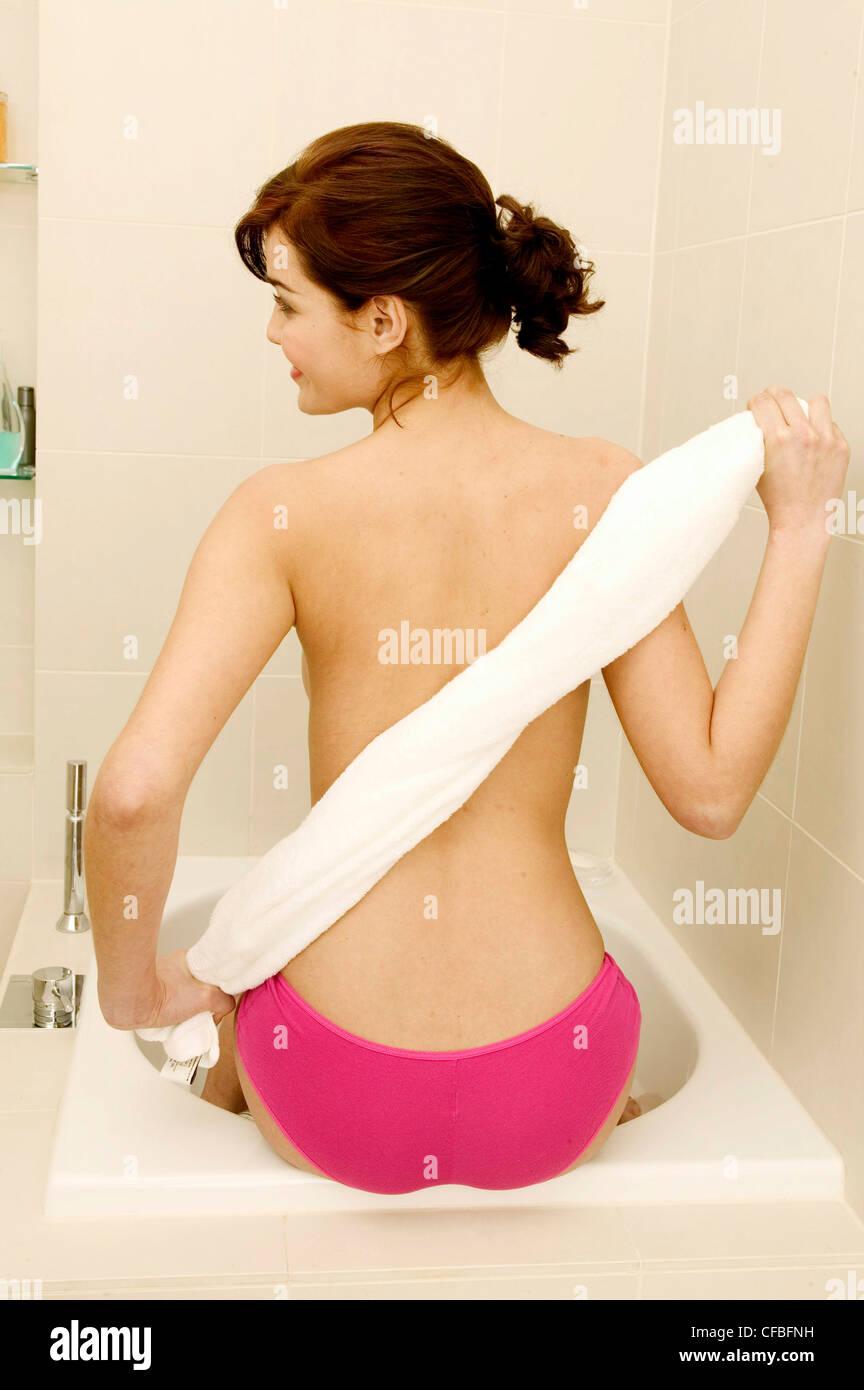 https://c8.alamy.com/comp/CFBFNH/female-brunette-hair-off-face-wearing-pink-knickers-sitting-on-edge-CFBFNH.jpg