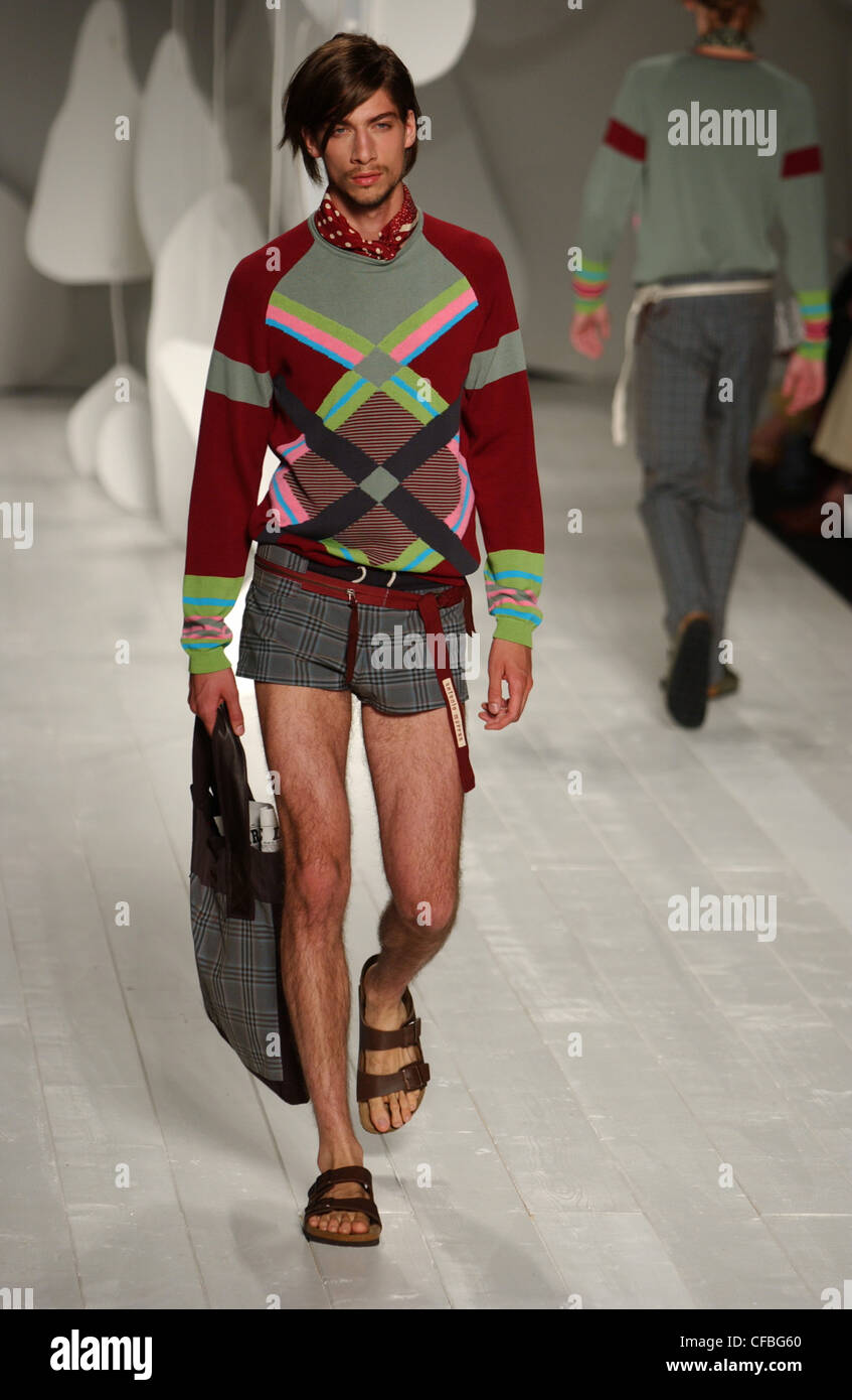 Antonio Marras Milan Menswear S S Male wearing patterned sweater tight checked grey hot pants and matching grey bag Stage prop Stock Photo