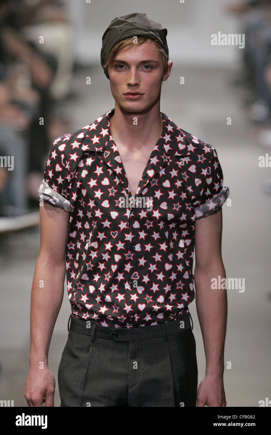Prada Milan Menswear S S Male wearing star and heart patterned shirt rolled  sleeves, and olive coloured hat Spectators in the Stock Photo - Alamy