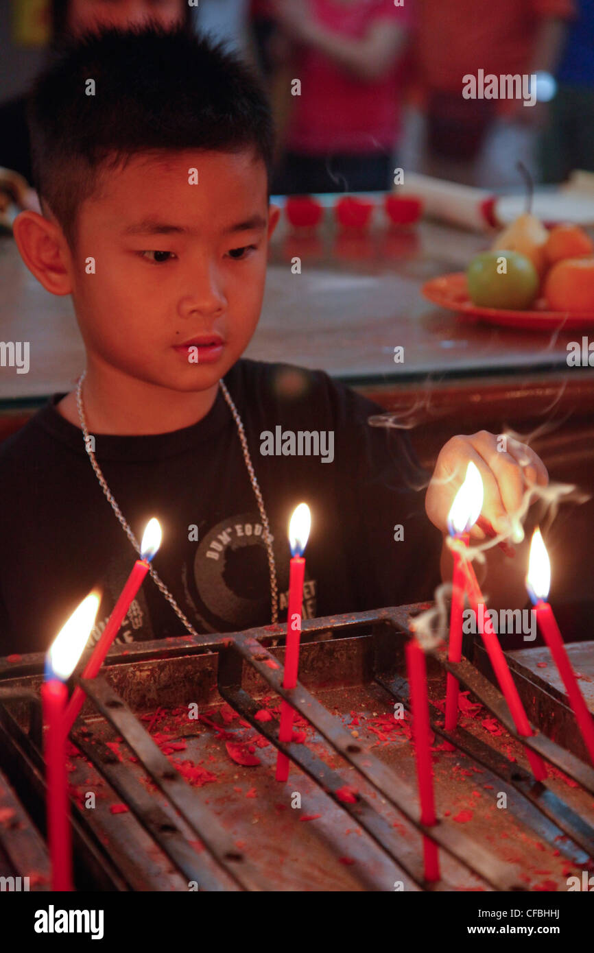 Child burning candles atChinese New Year celebrations in the temple