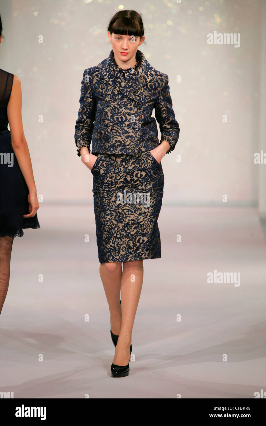 Brown and blue floral patterned damask dress and matching cropped jacket, black platform court shoes Stock Photo