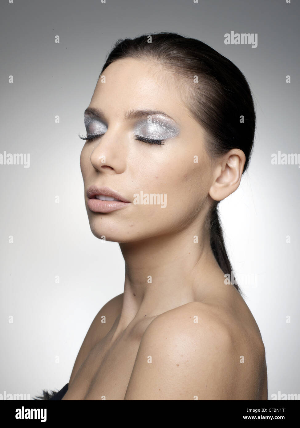 Female With Brunette Hair Tied Back Wearing Silver Shimmer Eyeshadow