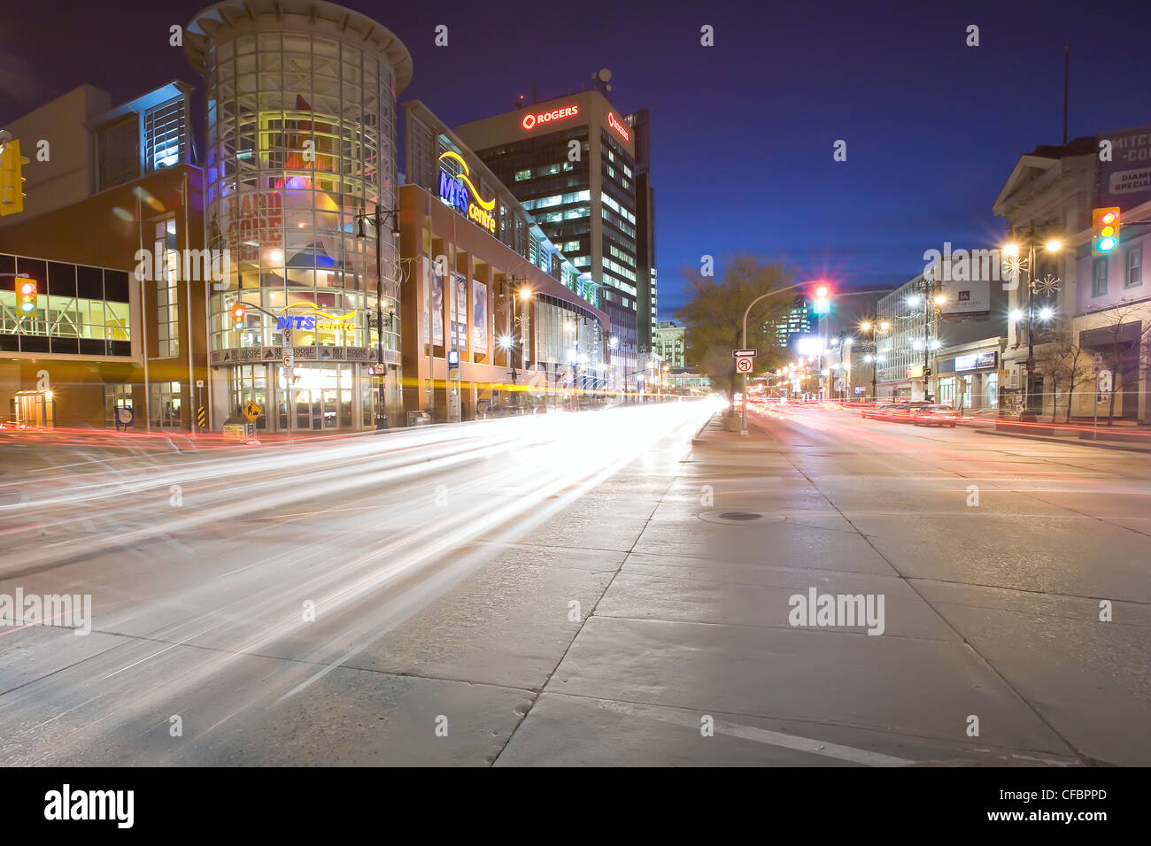 Traffic light trails and MTS Centre Arena at night. Portage Avenue, Winnipeg, Manitoba, Canada. Stock Photo