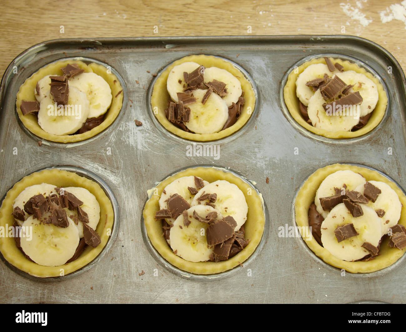 Making Chocolate and Banana Tartlets. Stock Photo