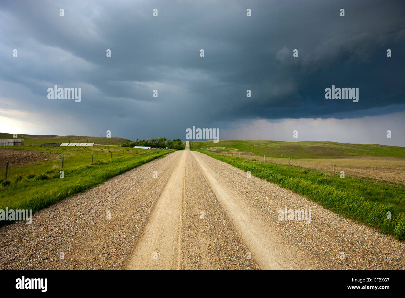 Storm clouds over a dirt road through the prairies, Saskatchewan, Canada. Stock Photo