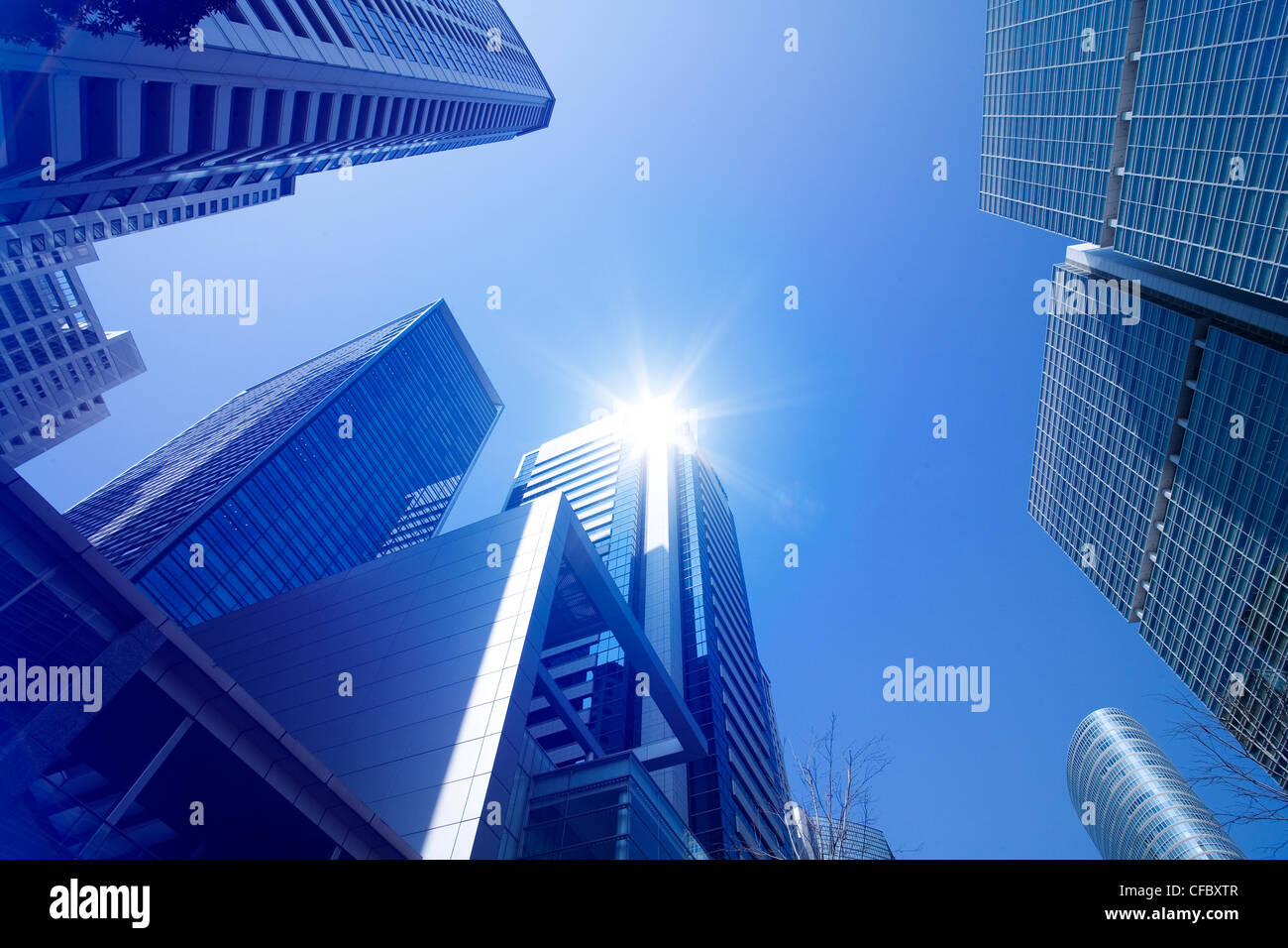 Looking up at tall skyscrapers against a blue sky in an urban ...