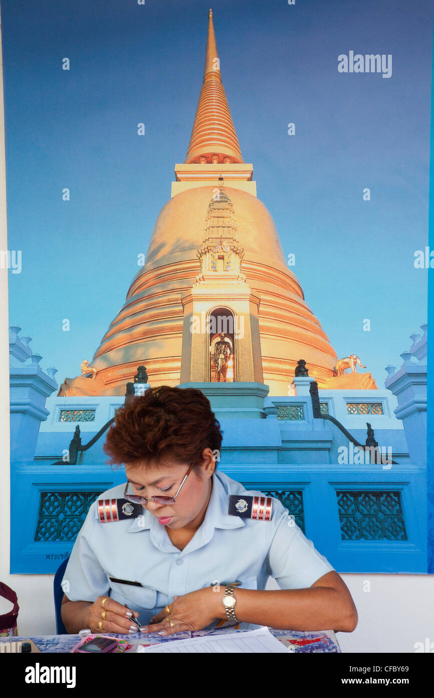Thailand, Bangkok, Uniformed Woman Cutting Fingernails Stock Photo