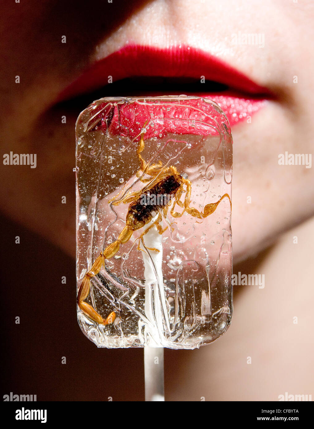 Horoscopes Scorpio A female wearing red lipstick with a scorpion lolly Stock Photo