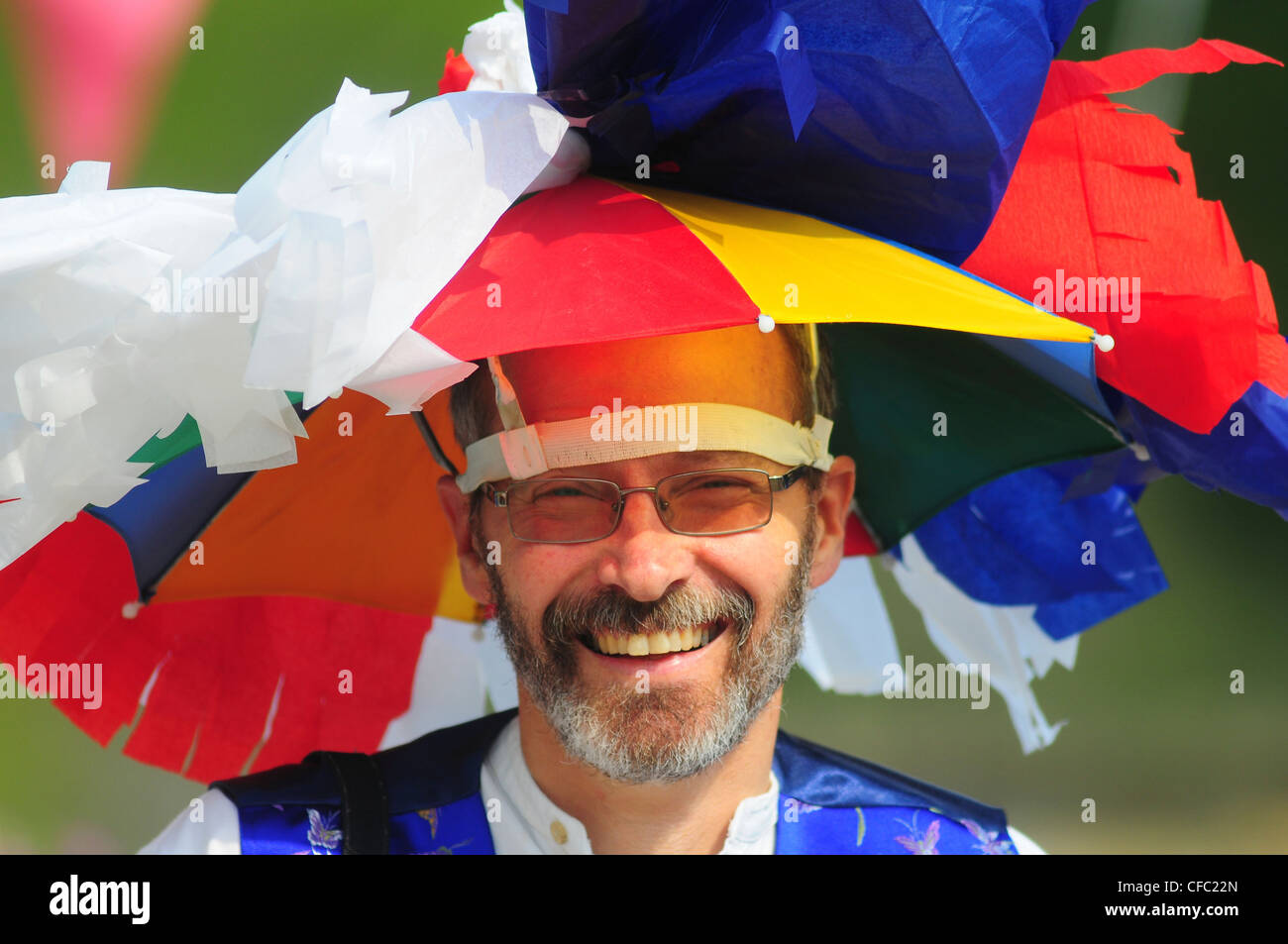 A man at a jubilee party celebration with a red, white and blue umbrella hat UK Stock Photo
