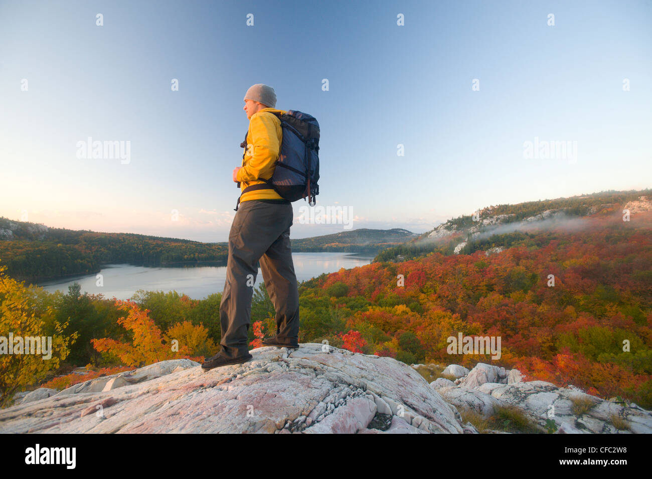 A male hiker on white quartzite ridges in Killarney Provincial Park ...