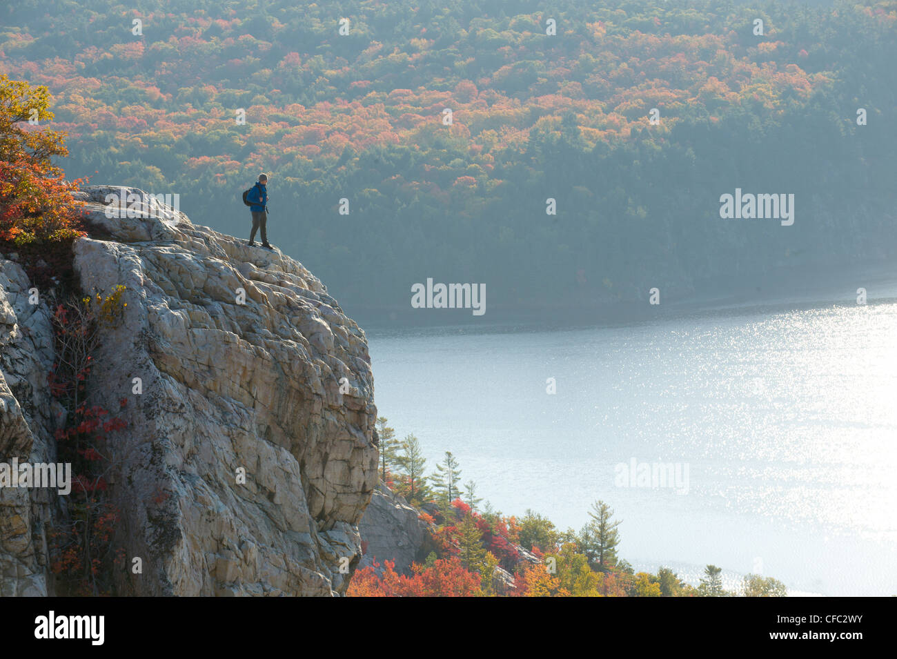 A male hiker on white quartzite ridges in Killarney Provincial Park ...