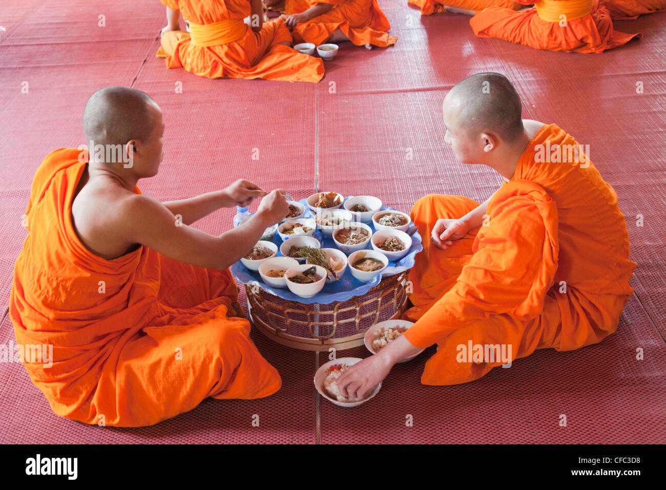 Laos, Vientiane, Monks Eating Morning Meal Stock Photo