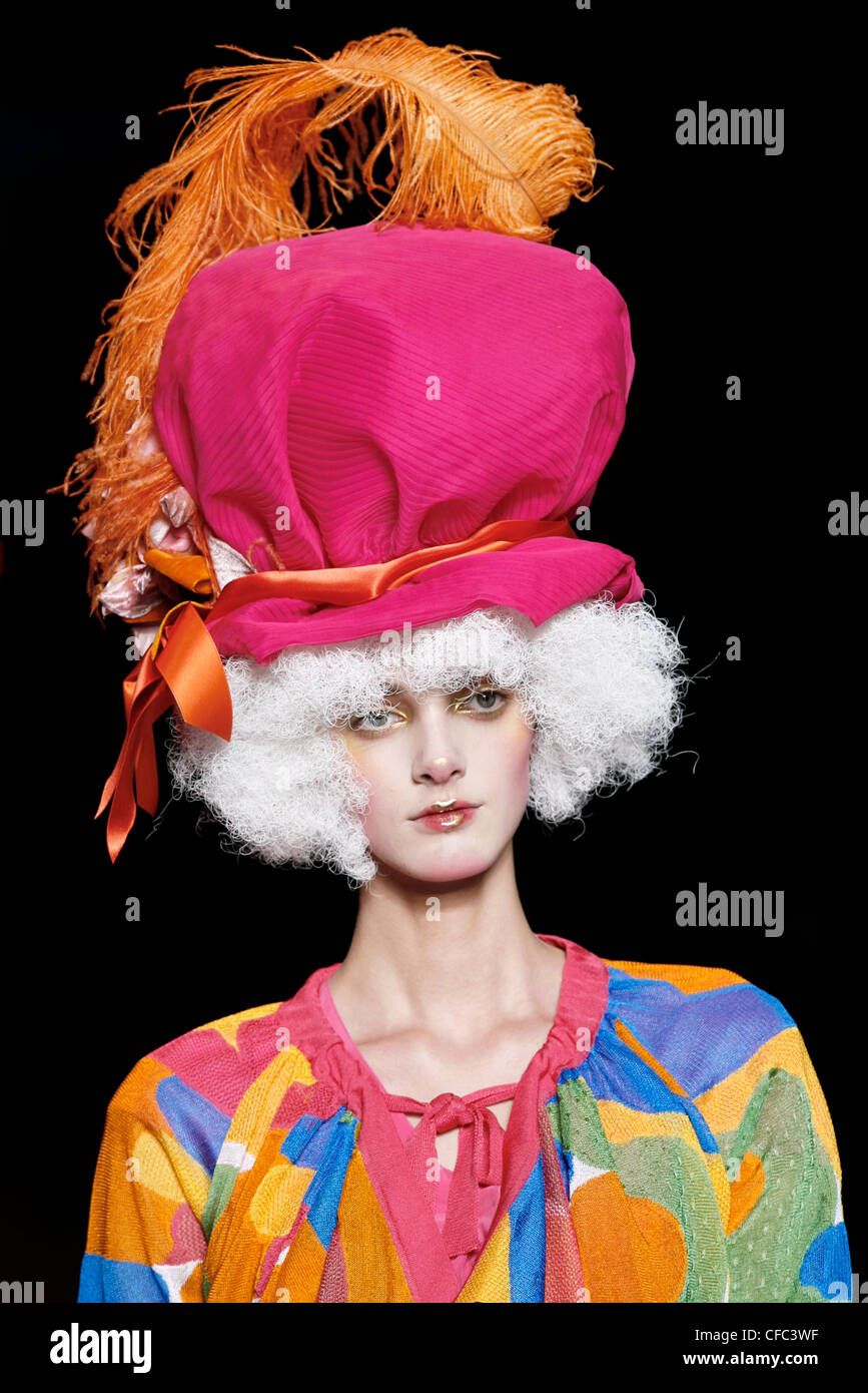 John Galliano Paris Ready to Wear Spring Summer Model wearing a colourful top, white wig and oversized pink hat orange ribbons Stock Photo