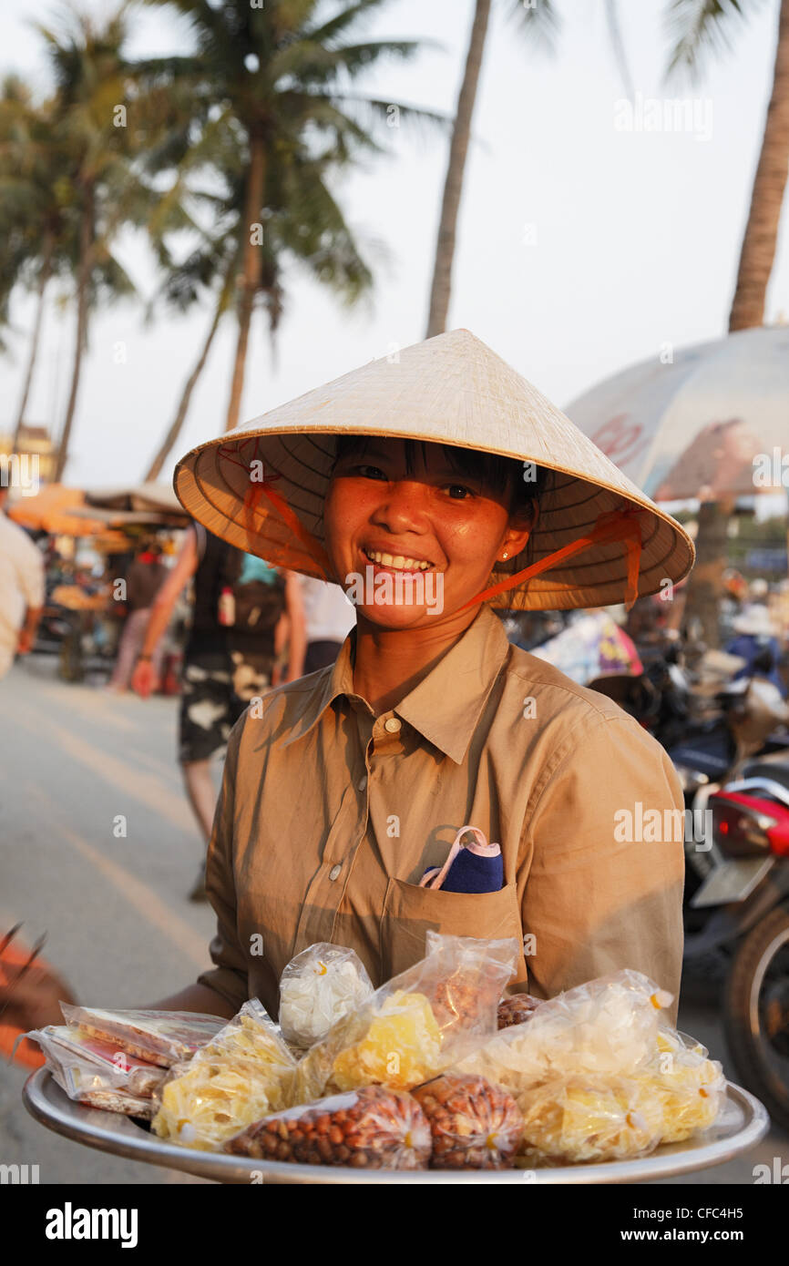 Woman offering sweets in harbor, Hoi An, Annam, Vietnam Stock Photo