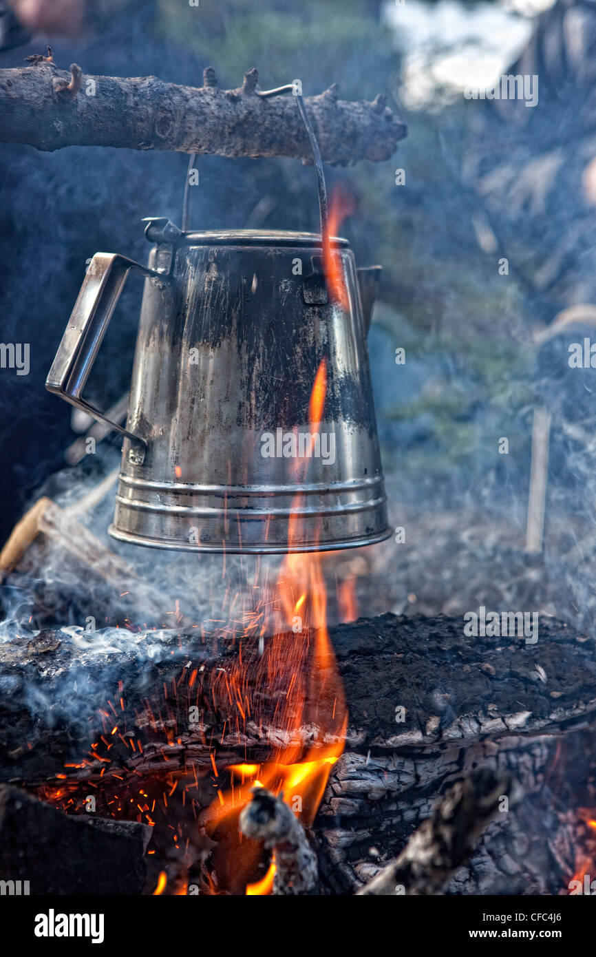 Kettle boiling over an open flame while camping, Atlin, British