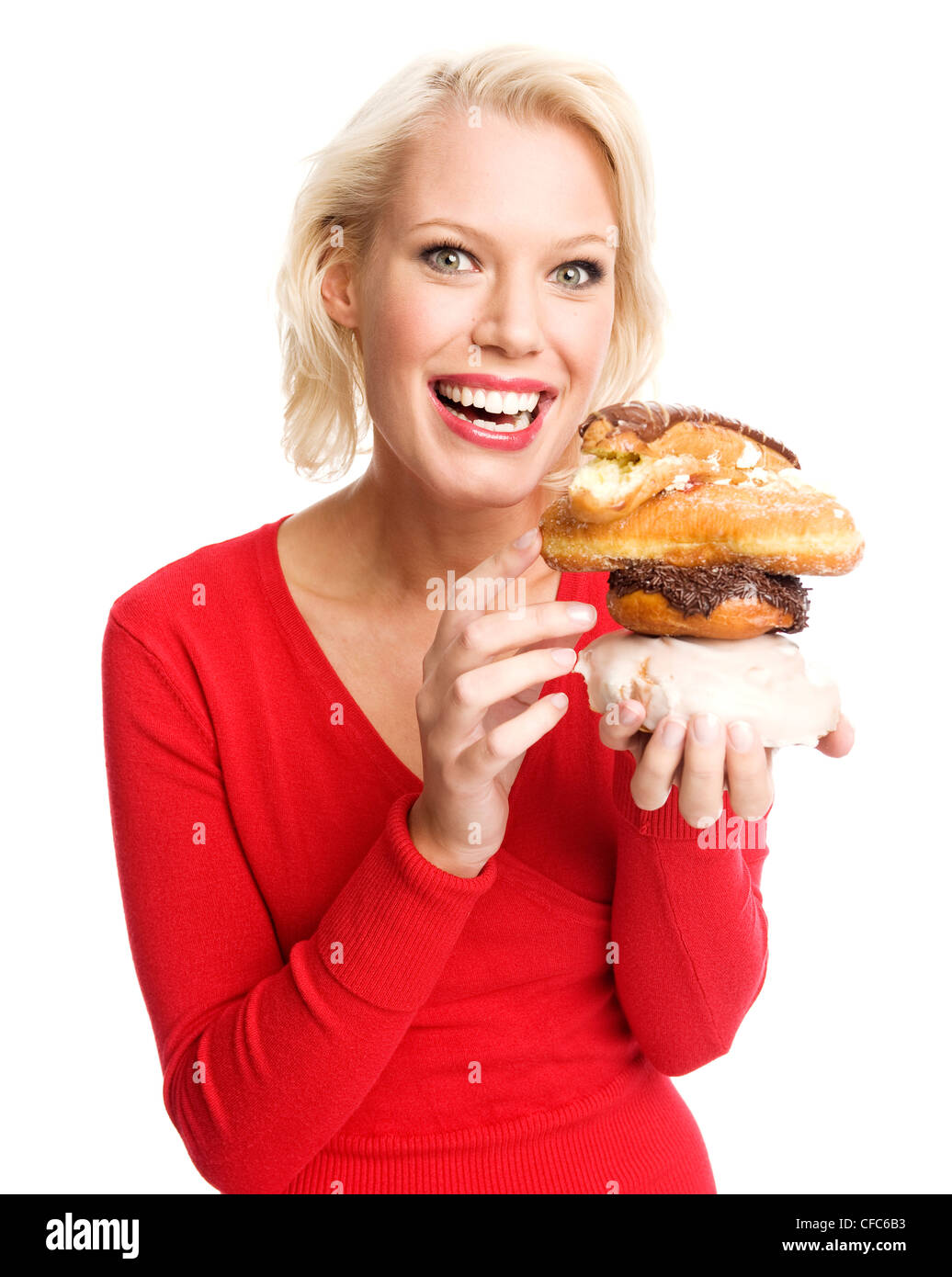 Female holding an iced bun, a chocolate donut, a sugared donut and a chocolate eclair piled up Stock Photo