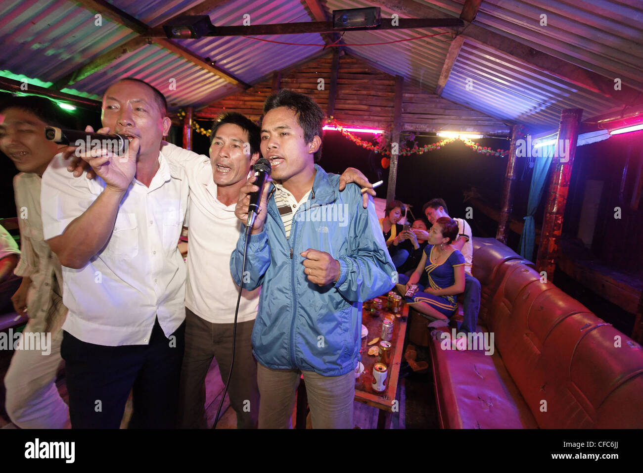 Men singing karaoke on a boat, Halong Bay, Quang Ninh, Vietnam Stock Photo
