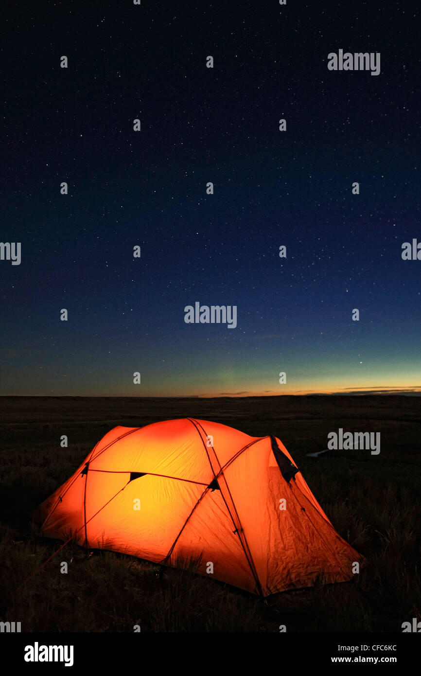 Tent lit up at night overlooking the Frenchman River Valley, Grasslands National Park, Saskatchewant, Canada. Stock Photo