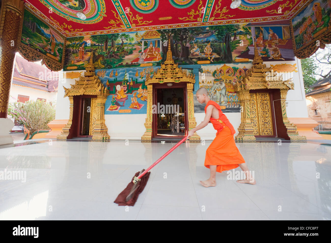 Monk sweeping temple floor vientiane hires stock photography and