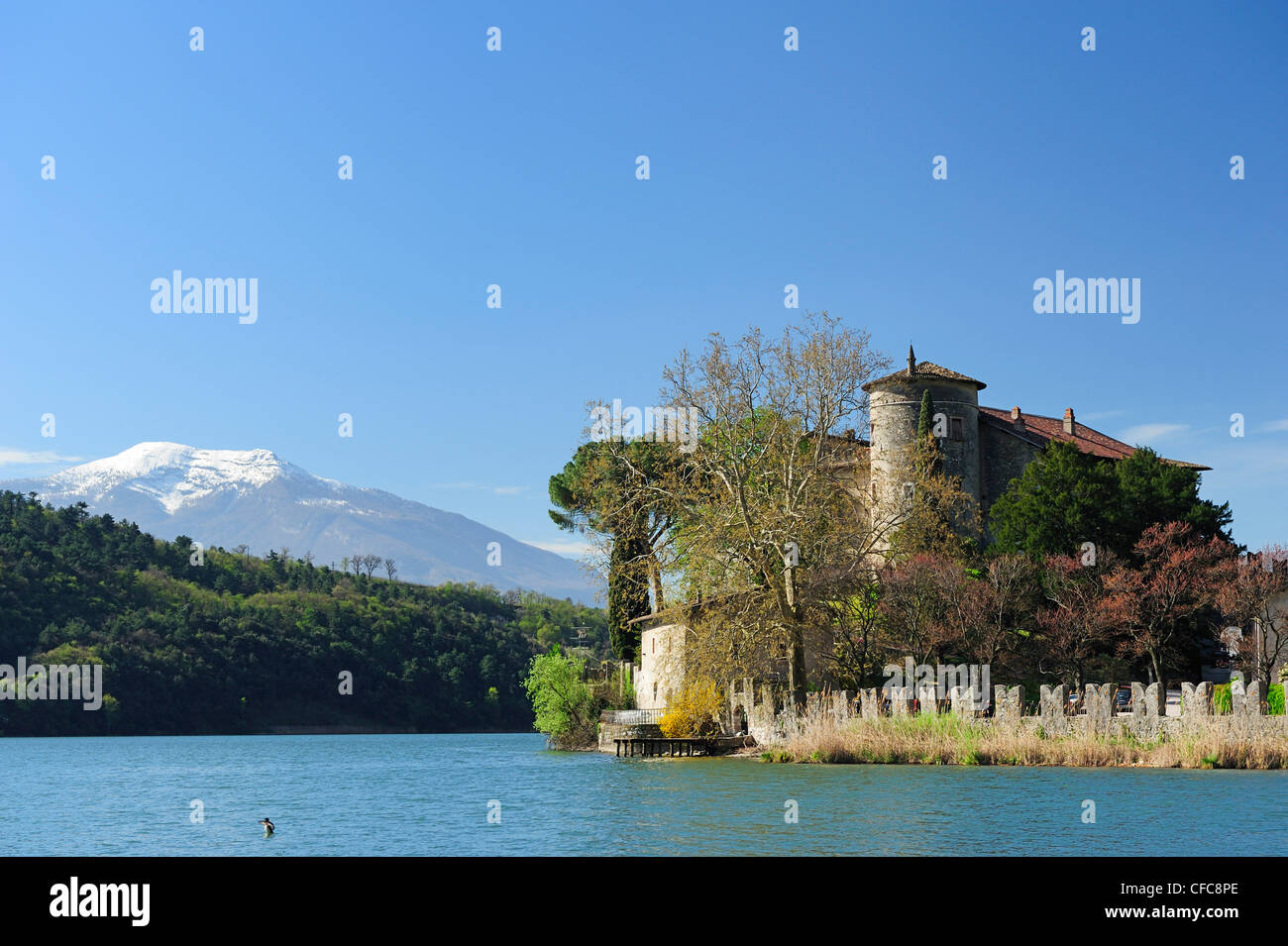 Castle Toblino in Lake Toblino with snow-covered Monte Baldo in background, Sarche, Trentino, Italy, Europe Stock Photo