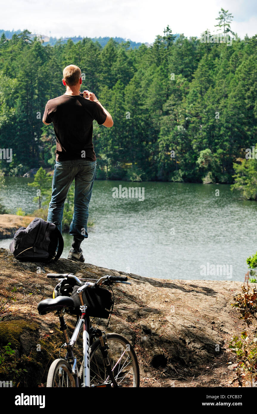 Mountain biker taking photo at Thetis Lake Regional Park in Victoria, British Columbia, Canada Stock Photo