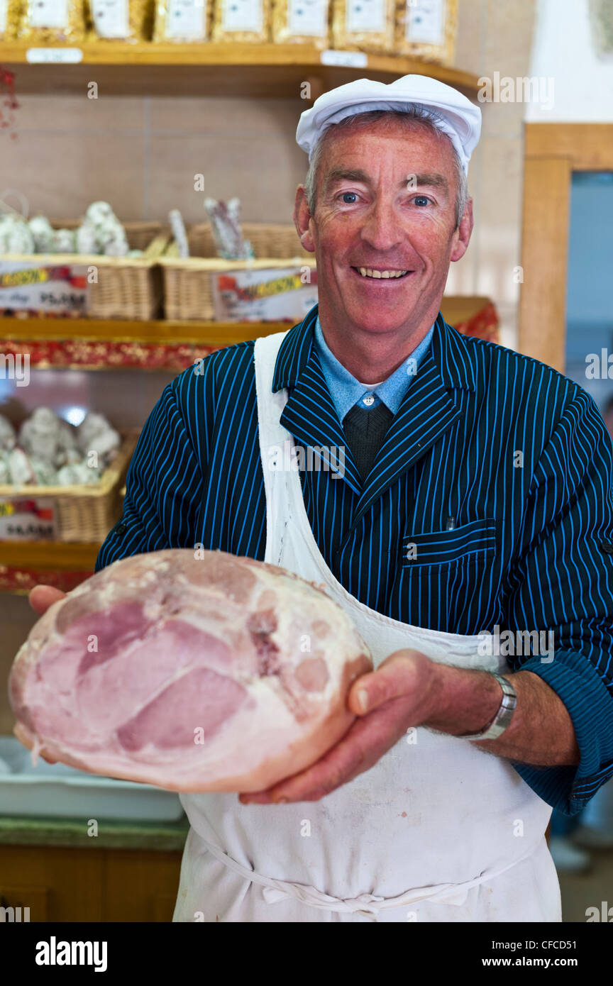 French delicatessen owner holding a ham Stock Photo Alamy